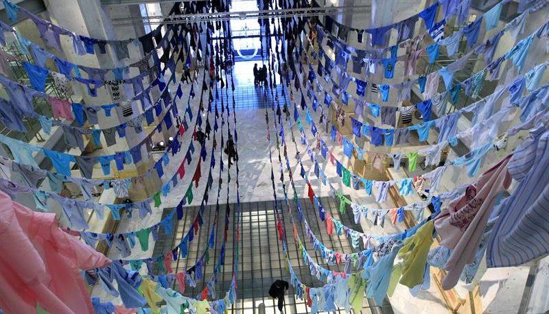 La artista finlandesa Kaarina Kaikkonen presenta su instalación 'Touching the sky', una instalación hecha de camisetas cosidas por las mangas. / Zipi (Efe)