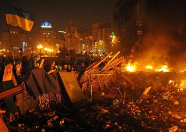 Un grupo de manifestantes en contra del Gobierno permanece tras una barricada en la Plaza de la Independencia, en el centro de Kiev (Ucrania). / Alexey Furman (Efe)