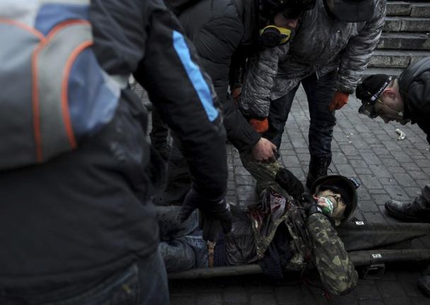 Activistas de la oposición trasladan el cuerpo sin vida de un manifestante durante los enfrentamientos contra la policía en la Plaza de la Independencia en Kiev. / Alexey Furman (Efe)