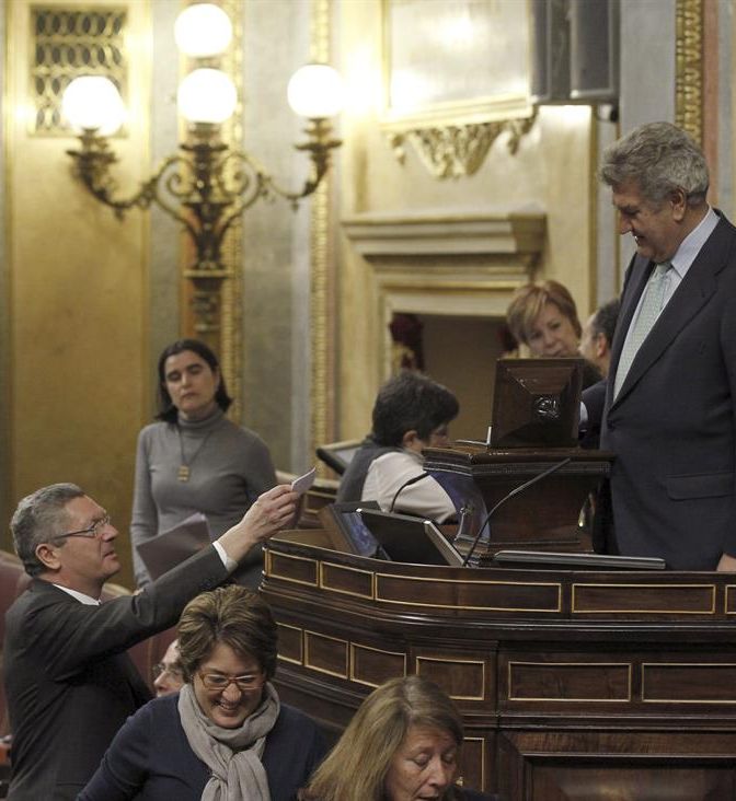 Alberto Ruiz-Gallardón, ayer, entregando su voto a favor de la tramitación de la nueva ley del aborto en el Congreso a su presidente, Jesús Posada. / Kiko Huesca (Efe)