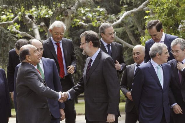 El presidente del Gobierno, Mariano Rajoy (c), saluda al presidente del Banco Santander, Emilio Botín (i), durante el posado para la fotografía de familia con los grandes empresarios españoles que integran el Consejo Empresarial por la Competitividad (CEC), con los que ha almorzado hoy en el Palacio de La Moncloa para analizar la evolución de la recuperación de la economía y el empleo.
