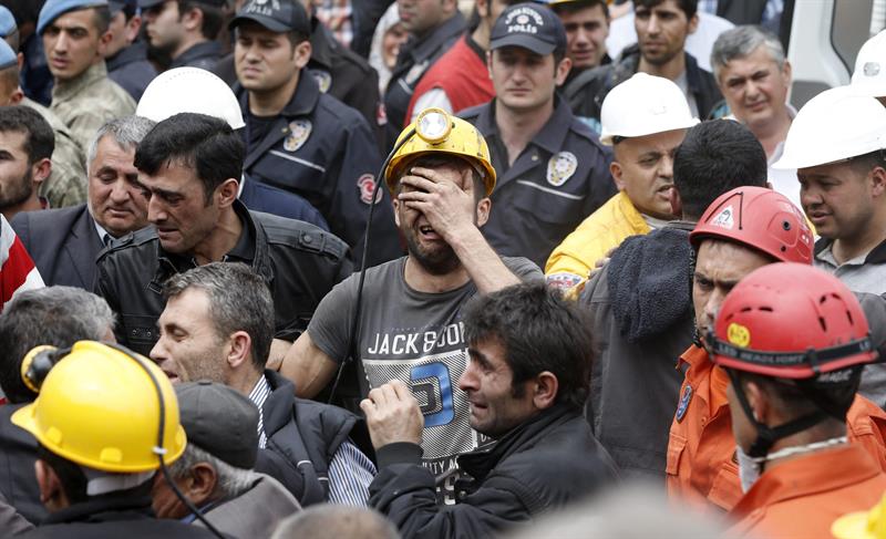 Compañeros y familiares de los mineros víctimas del accidente de Soma lloran a las puertas de la mina. / Tolga Bozoglu (Efe)