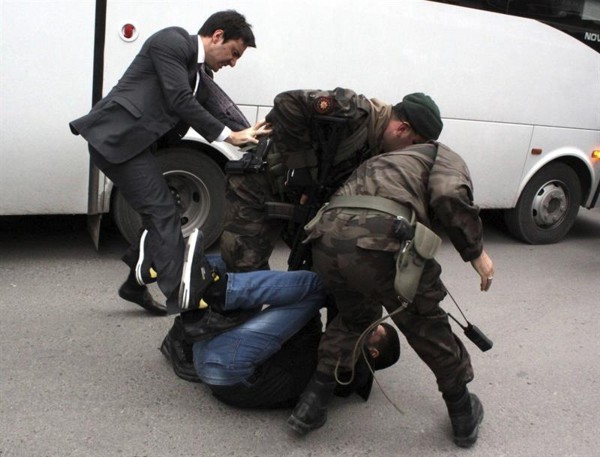El asesor de Erdogán Yusuf Yerkel da una patada a un manifestante ya reducido por dos soldados en Manisa. / Efe