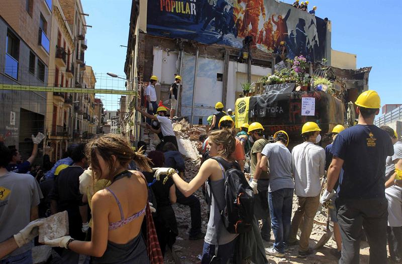Activistas del colectivo Can Vies, ayer sábado, iniciado la reconstrucción del edificio a medio derruir. / Toni Albir (Efe)