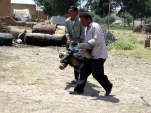 Dos lugareños trasladan uno de los cuerpos encontrados en la aldea. / Firat News