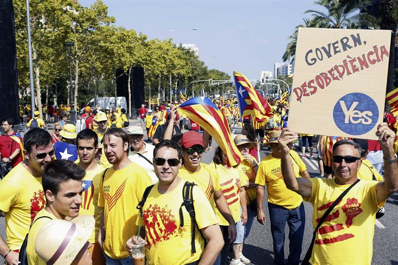 Un grupo de jóvenes llama a la desobediencia, aludiendo también al "yes" escocés a la indepedencia, de camino a la concentraciñon de la 'V'. / Alejandro García (Efe)