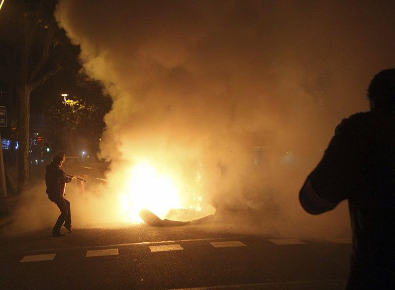 Contenedores ardiendo en la calle Córcega de Barcelona durante las protestas vividas ayer. / Toni Garriga (Efe)