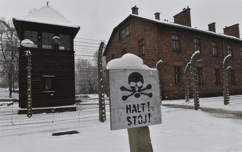 Imagen de este lunes de un cartel que prohíbe el paso ante la torre de vigilancia del campo de concentración alemán nazi Auschwitz I en Oswiecim (Polonia). / Jacek Bednarczyk (Efe)