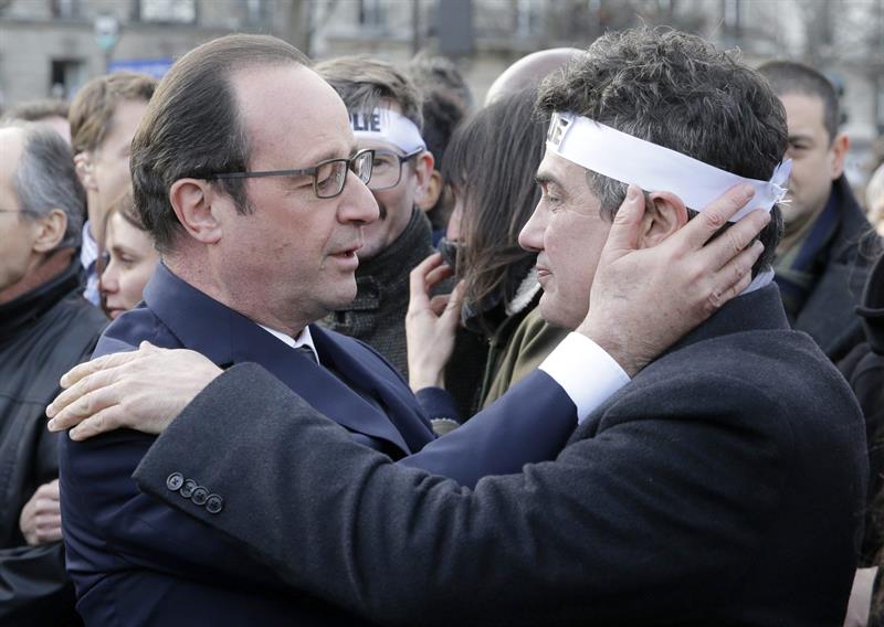 François Hollande abraza al columnista de 'Charlie Hebdo' Patrick Pellous, durante la marcha. / 