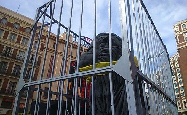 Una reproducción de uno de los leones de las Cortes, amordazado y enjaulado, ha acompañado a los manifestantes durante todo el recorrido. / nosomosdelito.net