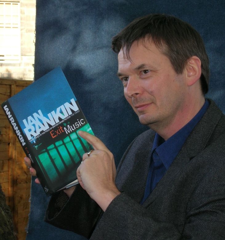 Ian Rankin sosteniendo un ejemplar de la serie de Rebus, Exit Music, traducido al español como 'La música del adiós'. / Wikipedia