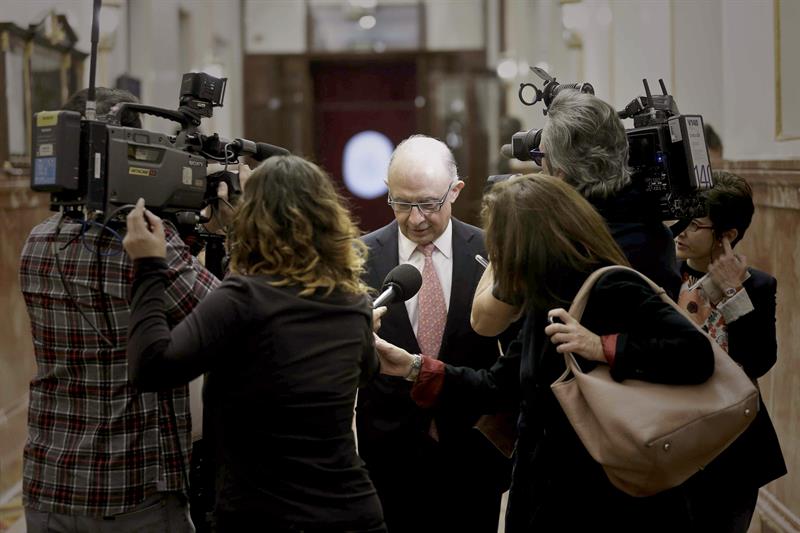 Cristóbal Montoro, ayer, atendiendo a un grupo de periodistas en los pasillos del Congreso. / Emilio Naranjo (Efe)
