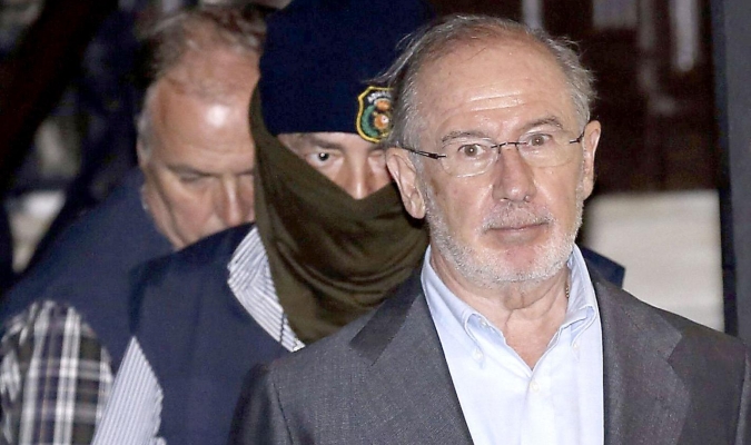 Rodrigo Rato, el pasado viernes, saliendo de su domicilio, una vez detenido, escoltado por agentes de Aduanas. / Efe