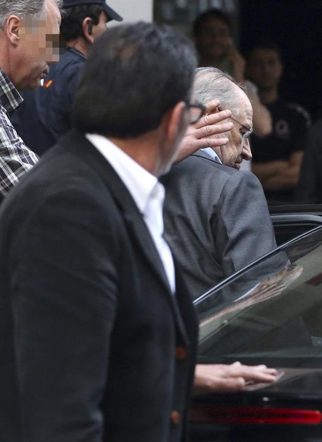 Rodrigo Rato es introducido en un coche policial, ayer, tras el registro de su domicilio en Madrid. / Ballesteros (Efe)