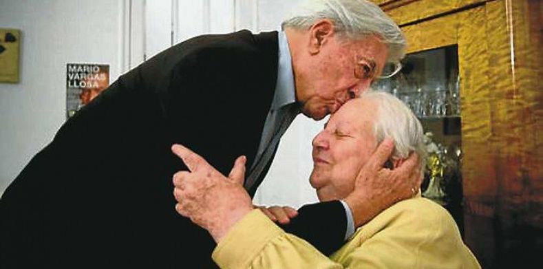 Mario Vargas Llosa besando en la frente a Carmen Valcells, agente del Premio Nobel. / Efe