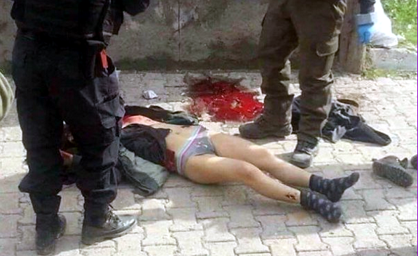 Fotografía de uno de los cuerpos medio desnudos junto a un charco de sangre y dos policías. / Bestanuce