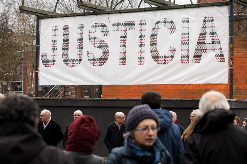 Familiares de las víctimas de los sucesos ocurridos en Vitoria en marzo de 1976, ayer, ante un mural presentado por la Asociación de Víctimas del 3 de marzo reclamando justicia. / David Aguilar (Efe)
