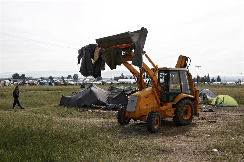 Un bulldozer destruye tiendas de campaña durante el desalojo del campamento de refugiados de Idomeni.