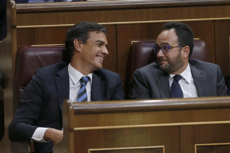 Sanchez y Hernando conversan sonrientes durante el discurso de Rajoy. 