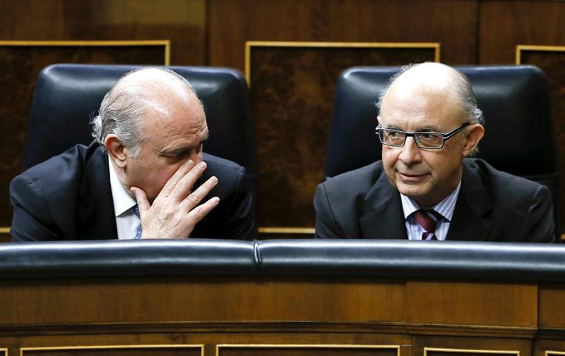 Jorge Fernández Díaz, a la izquierda, y Cristóbal Montoro, en una imagen de archivo durante un pleno del Congreso. / Efe