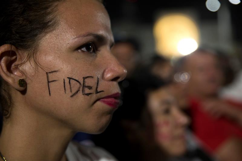 Una joven, con el nombre de Fidel pintado en la cara.
