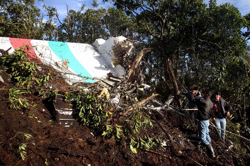 Varios campesinos observan los restos del avión accidentado en el municipio de La Unión. / Luis Eduardo Noriega A. (Efe)