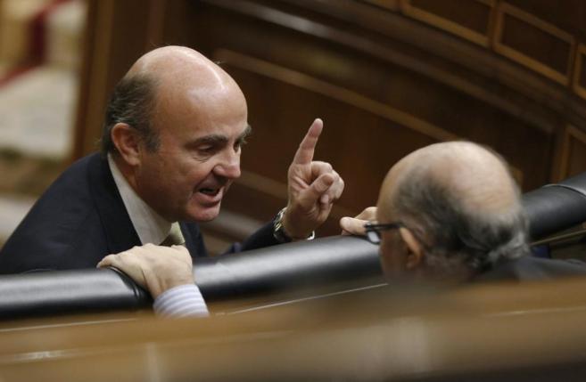 Imagen de archivo de Luis de Guindos, de frente, conversando en el Congreso con Cristóbal Montoro. / Efe