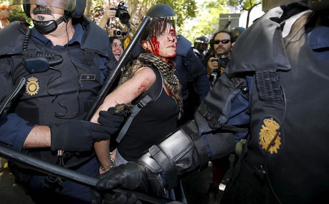 Agentes antidisturbios detienen a una manifestante, en una imagen de archivo. / Efe