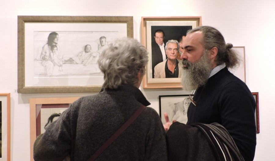 Gonzalo Goytisolo habla con Ton Carandell (de espaldas) ante el retrato de los hermanos Goytisolo/ fundacionvilacasas