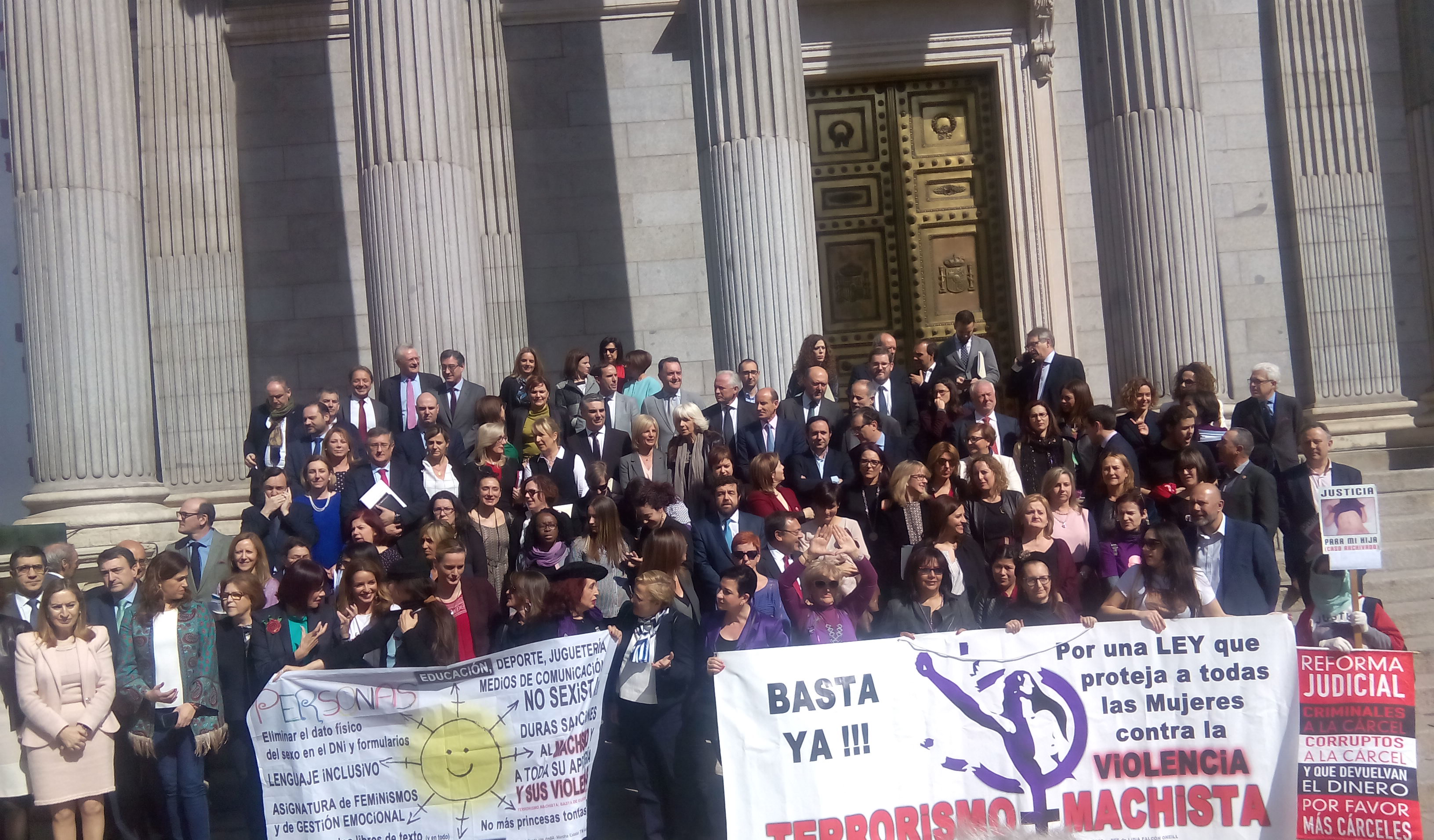 Diputadas y diputados posan en el Congreso con pancartas feministas por el Día de la Mujer.