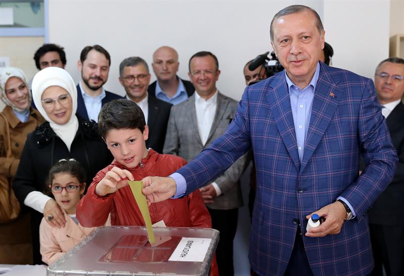 El nieto de Erdogan, Mehmet Akif, ayuda a su abuelo a introducir la papeleta en la urna