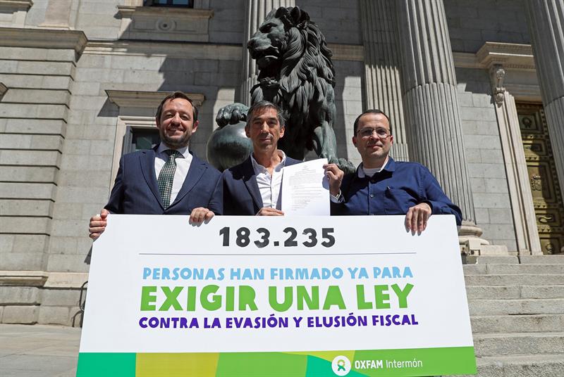 De izquierda a derecha, los diputado de Ciudadanos, Francisco de la Torre, del PSOE, Julián López-Milla, y el director de campaña de Oxfam, Rocardo Magán, antes de entregar más de 180.000 firmas en el Congreso de los Diputados para que los grupos políticos pidan al Gobierno una Ley contra la evasión y elusión fiscal para acabar con los paraísos fiscales.