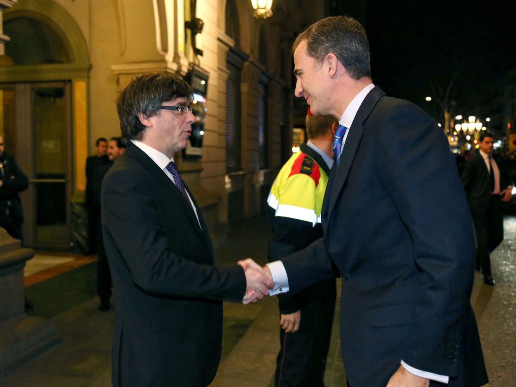 Carles Puigdemont recibe a pie de coche al rey Felipe VI, a la legada de éste último a Barcelona, en febrero de 2016, para presidir la inauguración del Mobile World Congress