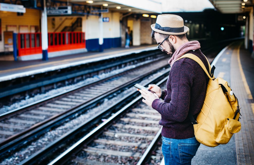 Roaming. Un turista consulta su móvil en una estación de tren.