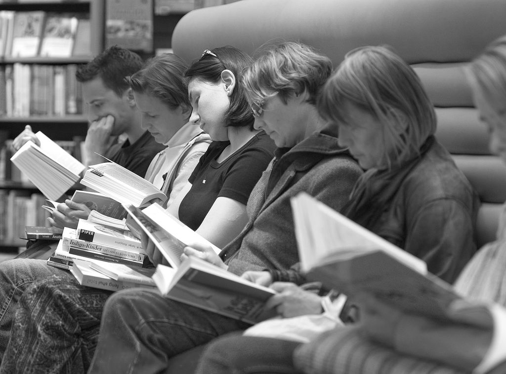 qué se lee en cada distrito de Madrid Un grupo de personas leyendo libros en una biblioteca pública