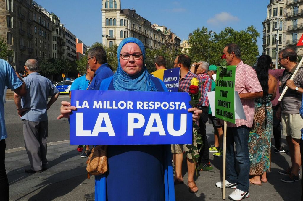 Una mujer de fe musulmana sostiene un cartel en el que se lee: "La millor resposta LA PAU" ("La mejor respuesta LA PAZ") momentos antes del inicio de la manifestación de Barcelona