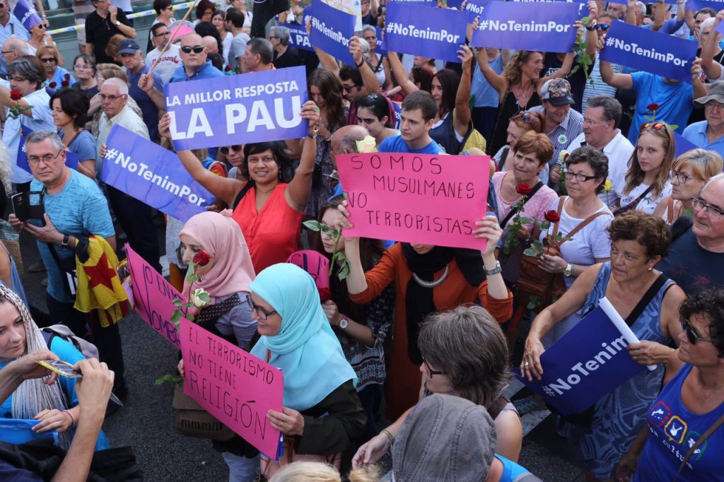 Un grupo de mujeres de confesión musulmana confundidas con la multitud exhiben carteles de confección casera en los que proclaman su rechazo al terrorismo