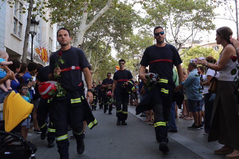La multitud hace el pasillo a los bomberos de Barcelona, uno de los colectivos designados como los héroes del 17-A