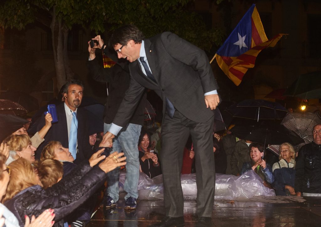 Carles Puigdemont, presidente de la Generalidad de Cataluña, saluda a algunos de los asistentes del acto, celebrado anoche en Girona, a favor del 'sí' en el referéndum del 1-O.