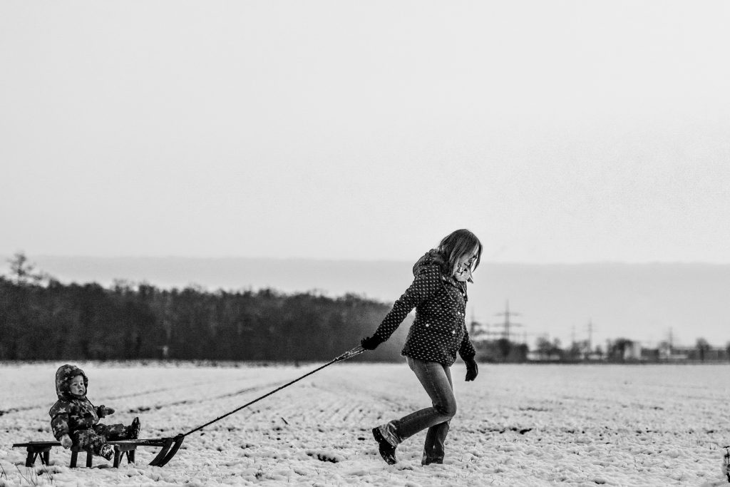 Una mujer arrastra por la nieve el trineo en el que va montado su bebé