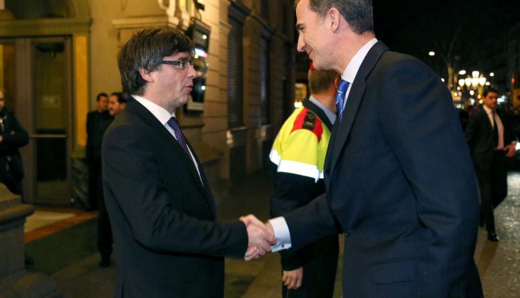 Carles Puigdemont recibe a pie de coche al rey Felipe VI, a la llegada de éste último a Barcelona, en febrero de 2016, para presidir la inauguración del Mobile World Congress.