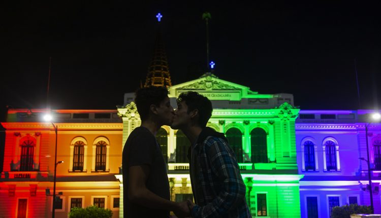 Una pareja se besa frente al Museo de las Artes (MUSA), iluminado por el Día Internacional del Orgullo LGBT en México, el 28 de junio de 2018, en la Universidad de Guadalajara, en el estado de Jalisco (México).