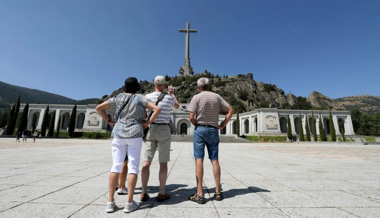 Varios visitantes fotografían el monumento del Valle de los Caídos