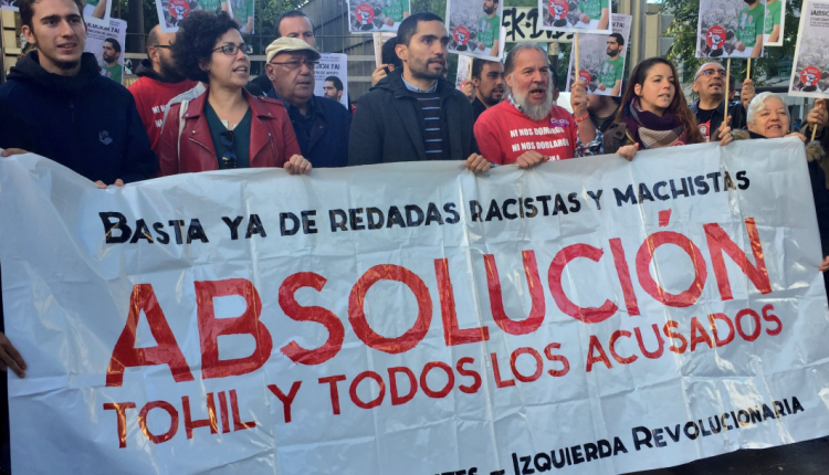 Tohil Delgado, exsecretario general del Sindicato de Estudiantes, en el centro de la imagen, sujetando la pancarta de la concentración de este lunes para apoyarle.