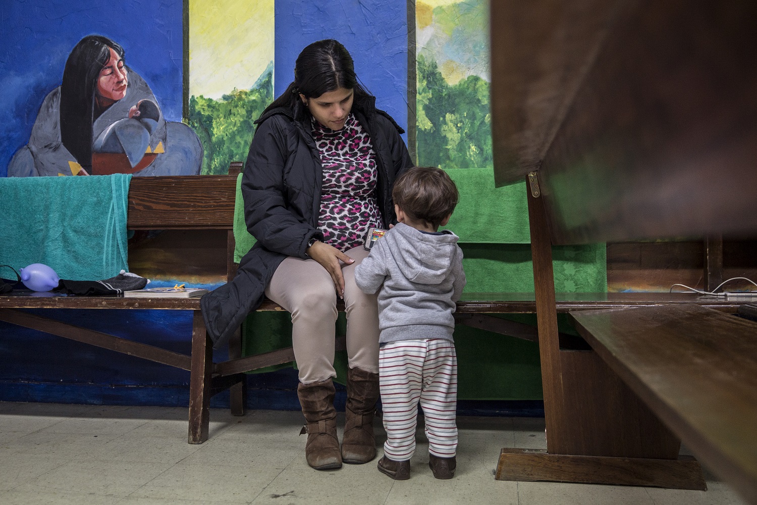 Una madre y su hijo solicitantes de asilo en el interior de la Parroquia.