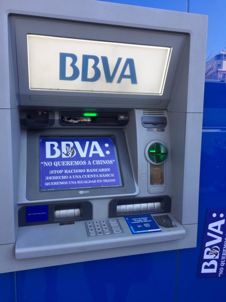 Cajero de BBVA con pegatinas de protesta de la comunidad.