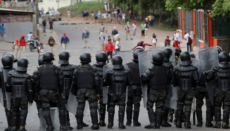 La Policía Militar del Orden Público y estudiantes de secundaria del Instituto Técnico Honduras se enfrentan durante una protesta por la defensa de la educación y la salud este miércoles, en Tegucigalpa (Honduras).
