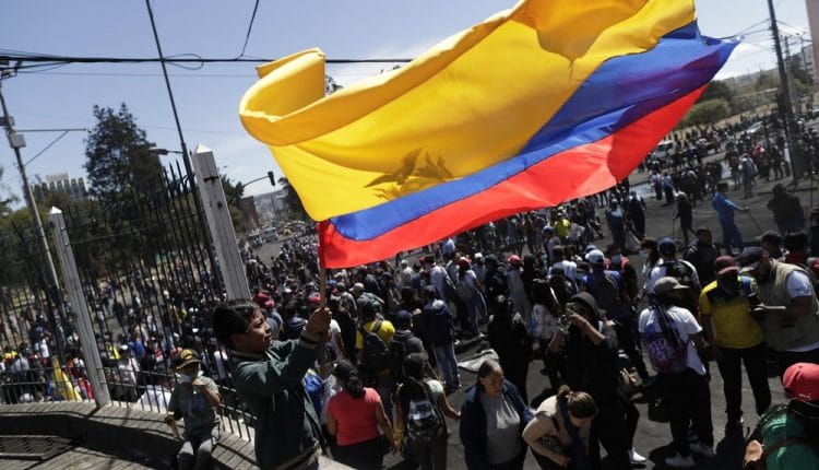 Un niño ondea una gran bandera ecuatoriana frente a decenas de ciudadanos y manifestantes que limpian las calles después de que se anunciara el fin de las protestas, este lunes, en Quito (Ecuador)./ Bienvenido Velasco (Efe)