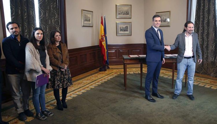 El presidente del Gobierno español en funciones, el socialista Pedro Sánchez (c), y el líder de Unidas Podemos, Pablo Iglesias, se estrechan las manos tras llegar hoy a un acuerdo./ Paco Campos (EFE)