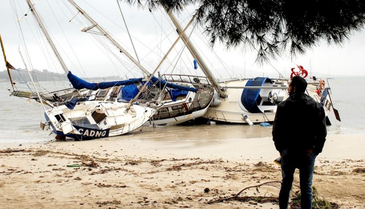 Un hombre mira tres de las embarcaciones varadas en la arena en el Port de Pollença (Mallorca) tras un temproal. EFE / Atienza 